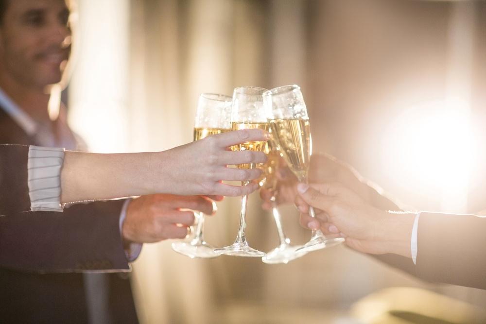 Close-up of group of businesspeople toasting glasses of champagne in the office.jpeg