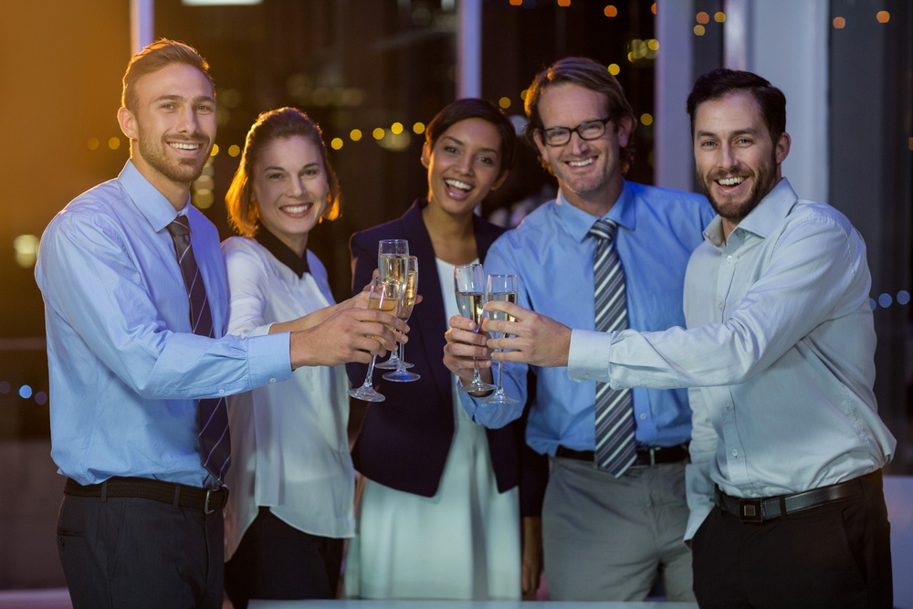Portrait of Business People Toasting Glasses of Champagne in Office at Night