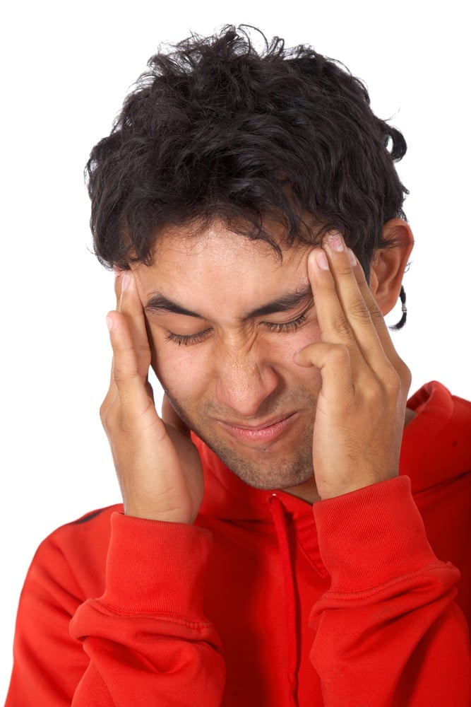 casual man with a headache isolated over a white background